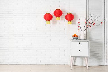 Çin Yeni Yılı için dekore edilmiş odanın içinde masa, fener ve katlanmış ekran var.