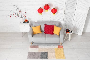 Çin Yeni Yılı için dekore edilmiş oturma odasının içi kanepe, masa ve katlanır ekran ile süslenmiş.