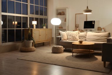 Gri kanepeli, çekmeceli ve parlak lambalı oturma odasının içinde.