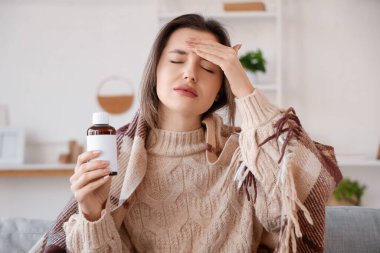 Öksürük şurubu ve ekoseli hasta genç kadın.