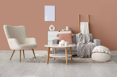 Oturma odasında kanepe, masa, puf ve sandık dolu beyaz koltuk.