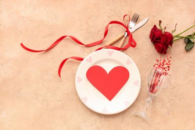 Kırmızı güller ve bej arka planda kağıt kalp ile güzel bir masa. Sevgililer Günü kutlaması