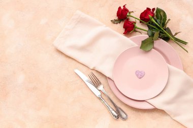 Bej arka planda kırmızı güller olan güzel bir masa. Sevgililer Günü kutlaması