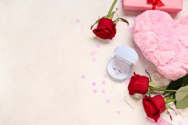 Nişan yüzüğü ve beyaz arka planda gül çiçekleri olan güzel bir kompozisyon. Sevgililer Günü kutlaması