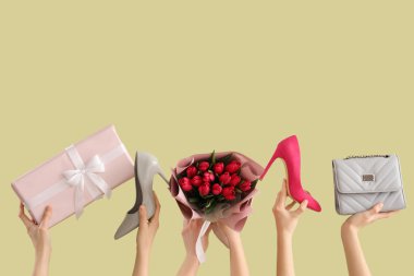 Lale buketi, hediye kutusu ve yeşil arka planda yüksek topuklu ayakkabıları olan kadın elleri. Uluslararası Kadınlar Günü için Alışveriş