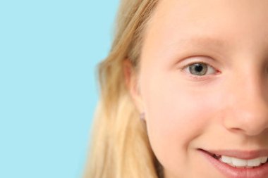 Mavi arka planda genç bir kız, yakın plan. Çocuk Göz Sağlığı ve Güvenlik Bilinci Ayı