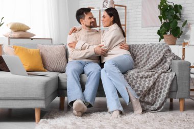 Genç çift, sonbahar günü evde sarılıyor.