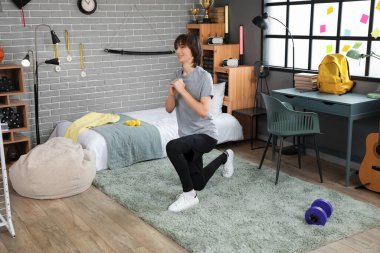 Erkek öğrenci yatak odasında eğitim görüyor.