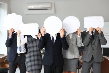 Ofisinde boş konuşma baloncukları olan bir grup iş adamı.