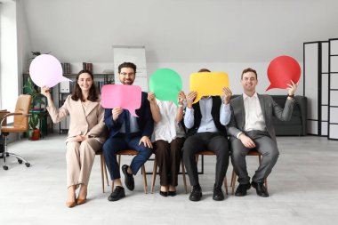 Ofiste boş konuşma baloncukları olan bir grup iş adamı oturuyor.