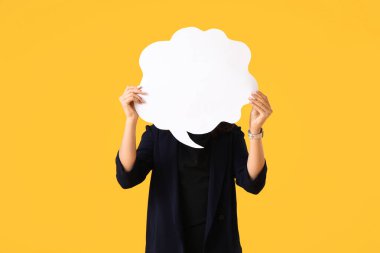 Sarı arka planda boş konuşma balonu olan genç bir iş kadını.