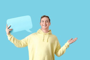 Mavi arka planda boş konuşma balonu olan genç bir adam.