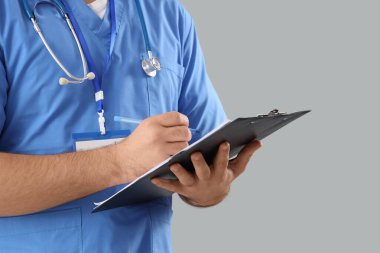 Gri arkaplanı olan erkek doktor, yakın plan.