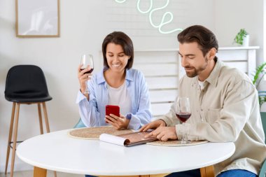 Genç çift menü okuyor ve kafede şarap içiyor.