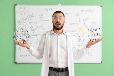 Stresli kimyagerler yeşil arka planda beyaz tahtaya karşı