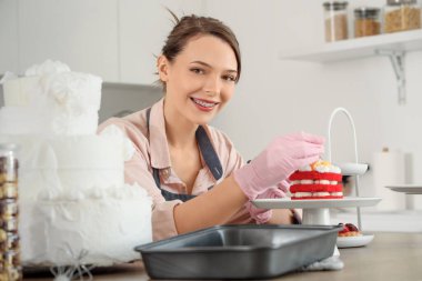 Mutfakta pastayı süsleyen kadın pastacı.