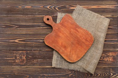 Ahşap arka planda kesim tahtası olan çuval bezi.