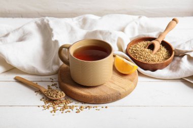 Beyaz ahşap arka planda limonlu sıcak karabuğday çayı.