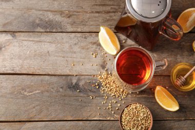 Cam bardak ve çaydanlık sıcak karabuğday çayı limonlu ve ahşap zemin üzerinde bal kasesi