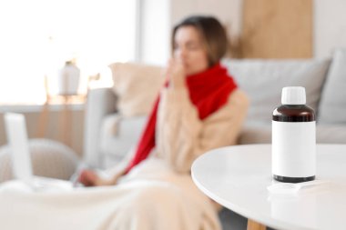 Evde dizüstü bilgisayar kullanarak hasta kadına karşı öksürük şurubu.