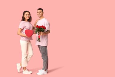 Sevgi dolu genç bir çift hediye kutusu ve pembe arka planda güzel güller. Sevgililer Günü 'nün kutlaması