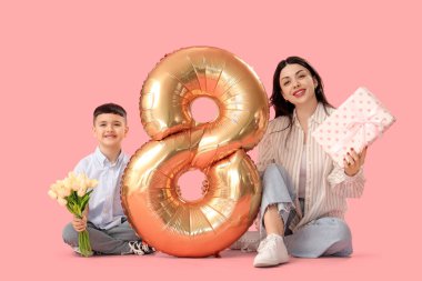 Küçük oğlu lale, hediye ve hava balonu tutan güzel bir kadın. Pembe arka planda 8 figürü var. Uluslararası Kadınlar Günü