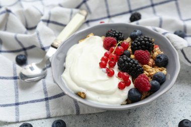 Hafif arkaplanda yoğurt olan bir kase lezzetli granola.