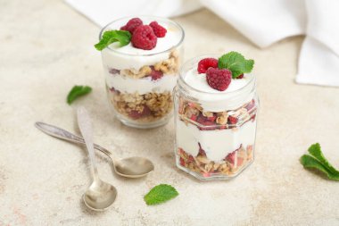 Hafif arkaplanda yoğurt ve bir kavanoz lezzetli granola.