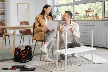 Mutfakta rafları elle monte eden mutlu çift.