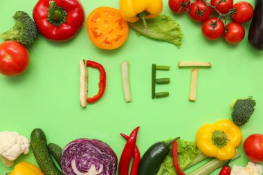 Diyet kelimesiyle kompozisyon ve yeşil arka planda farklı taze sebzeler