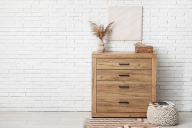 Çekmece sandığı, puf ve resim beyaz tuğla duvarda.