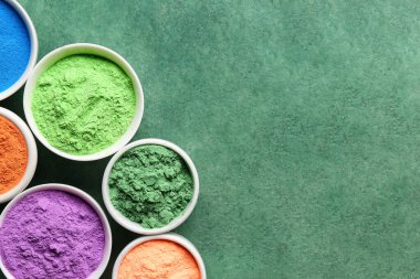 Yeşil arka planda farklı renk toz pigmentleri olan kaseler