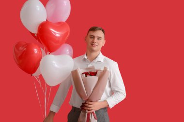 Kırmızı arka planda çiçek buketi ve kalp şeklinde balonları olan yakışıklı bir genç. Sevgililer Günü kutlaması