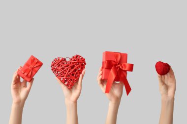 Kalpli kadın elleri ve gri arka planda hediye kutuları. Sevgililer Günü kutlaması