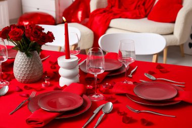 Sevgililer Günü için hazırlanmış şölen masası kırmızı güller ve evde yanan mumlarla süslenmiş.
