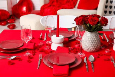 Sevgililer Günü için hazırlanmış şölen masası kırmızı güller ve evde yanan mumlarla süslenmiş.