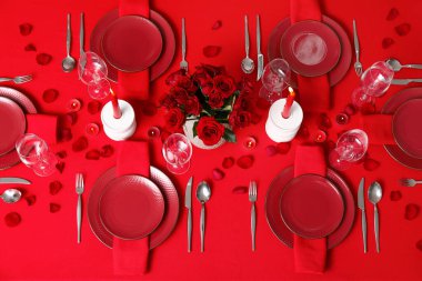 Sevgililer Günü kutlaması için yemek masası, mumlar ve kırmızı güller.
