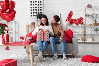 Genç adam sevgilisini sevgililer gününde evde karşılıyor.