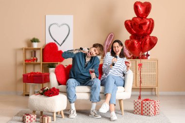 Evde şarap içen genç bir çift. Sevgililer Günü Kutlaması