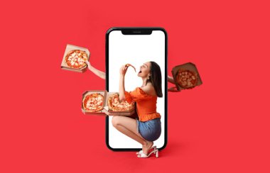 Lezzetli pizza yiyen genç ve güzel bir kadın. Elinde karton kutular ve kırmızı arka planda büyük bir akıllı telefon olan bir sürü el.