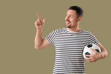 Futbol toplu bir adam arka plandaki bir şeyi işaret ediyor.