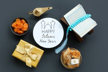Yeni Yıl, Kur 'an, şekerler ve karanlık arka planda hediye kutusu içeren metin Mutlu İslami Kart