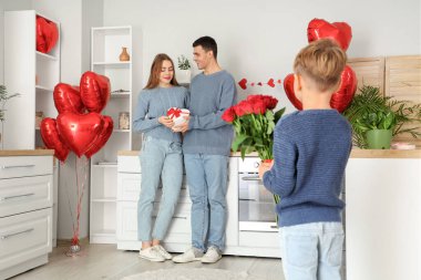 Hediyeli mutlu bir aile ve Sevgililer Günü 'nde küçük oğlu mutfakta.