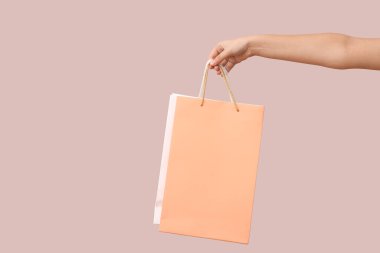 Işık arka planında kağıt alışveriş torbaları olan bir kadın. Sevgililer Günü kutlaması