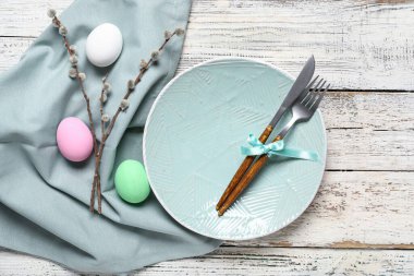 Paskalya için çok güzel bir sofra. Yumurtalar ve söğüt dalları açık ahşap arka planda.