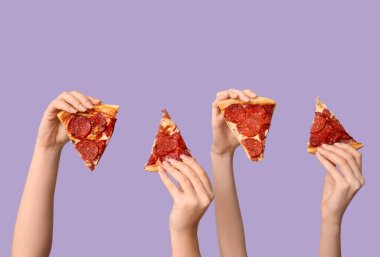 Leylak arka planında pizza dilimleri tutan bir sürü el.