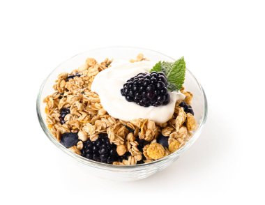 Beyaz arka planda yoğurtlu bir kase lezzetli granola.