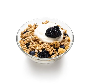 Beyaz arka planda yoğurtlu bir kase lezzetli granola.