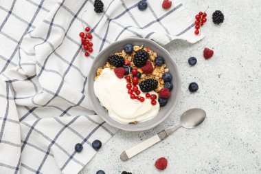 Hafif arkaplanda yoğurt bulunan bir kase lezzetli granola.