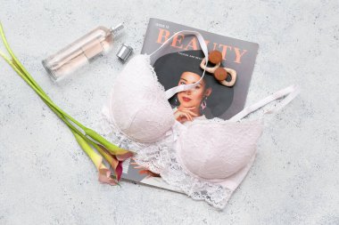 Şık bayan sütyeni, dergisi, parfümü ve çiçekli kompozisyon
